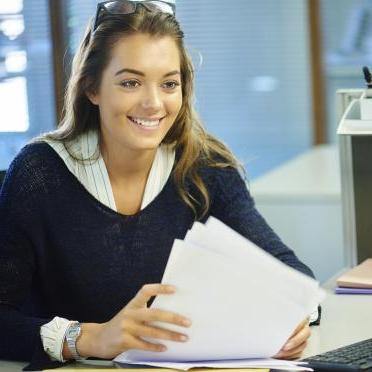 一个学生微笑着坐着处理文书工作