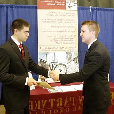 Career services career fair image featuring finance recruiter and male student