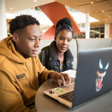 两名皇冠365app首页的学生坐在笔记本电脑前工作.