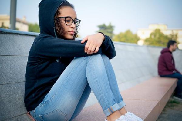 一个悲伤的年轻的美国黑人女孩独自在城市的街道上